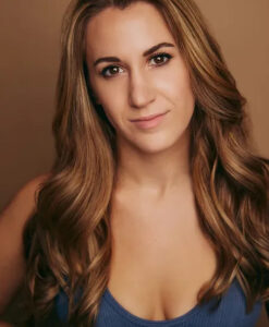 Headshot of Katie Miller, featuring her warm smile and wavy blonde hair, exuding a confident and approachable demeanor.